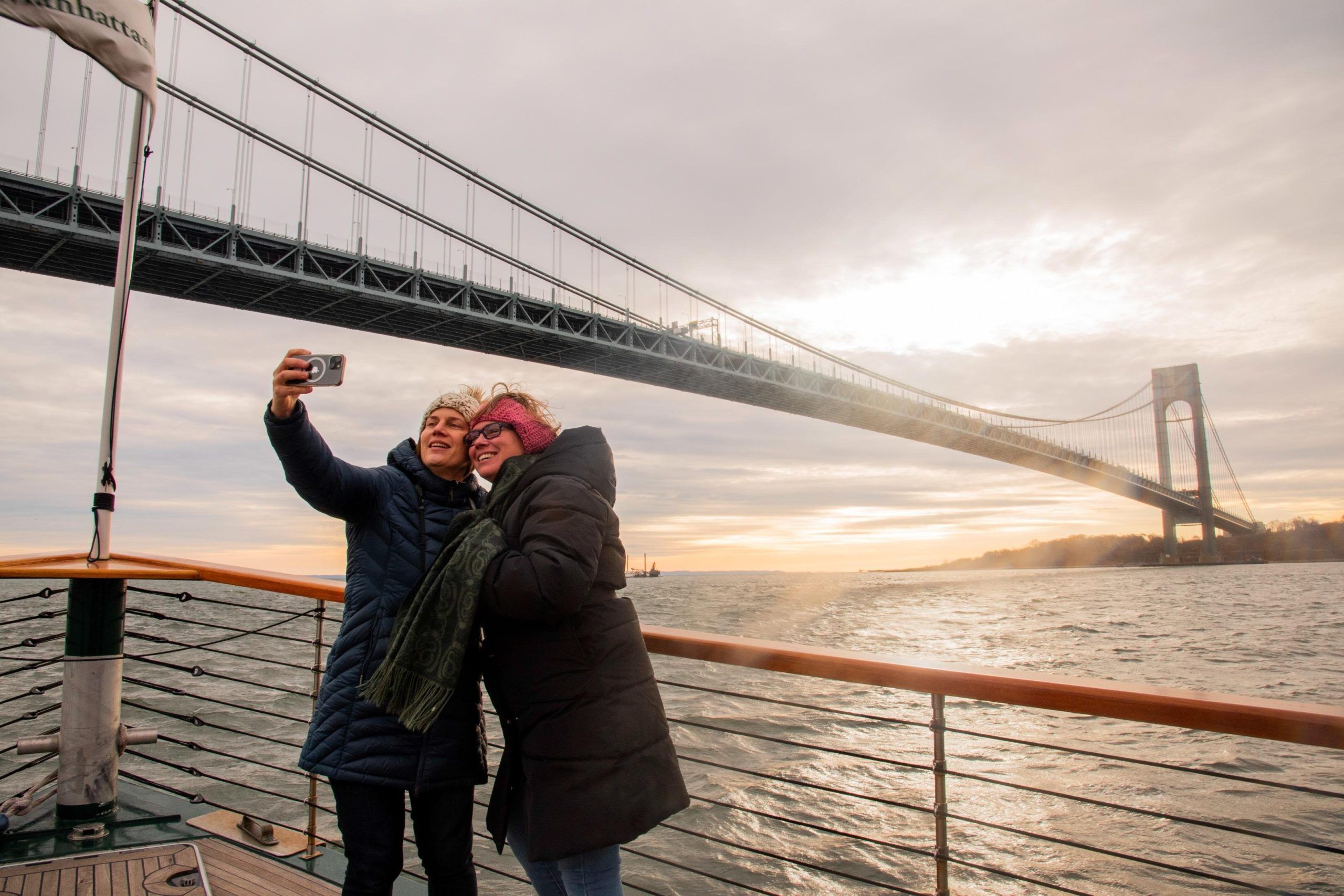 Women taking photos under the Verrazzano-Narrows Bridge in New York