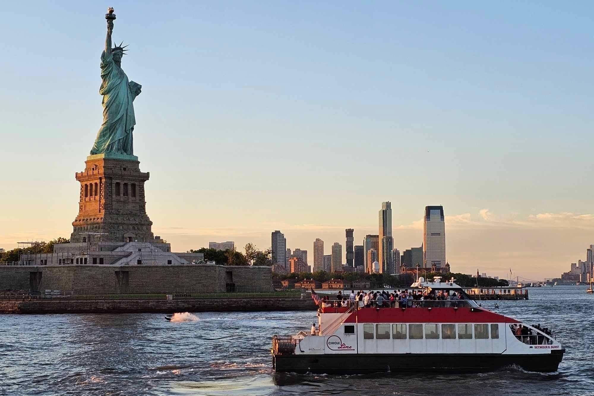 Boat passing the Statue of Liberty at sunset