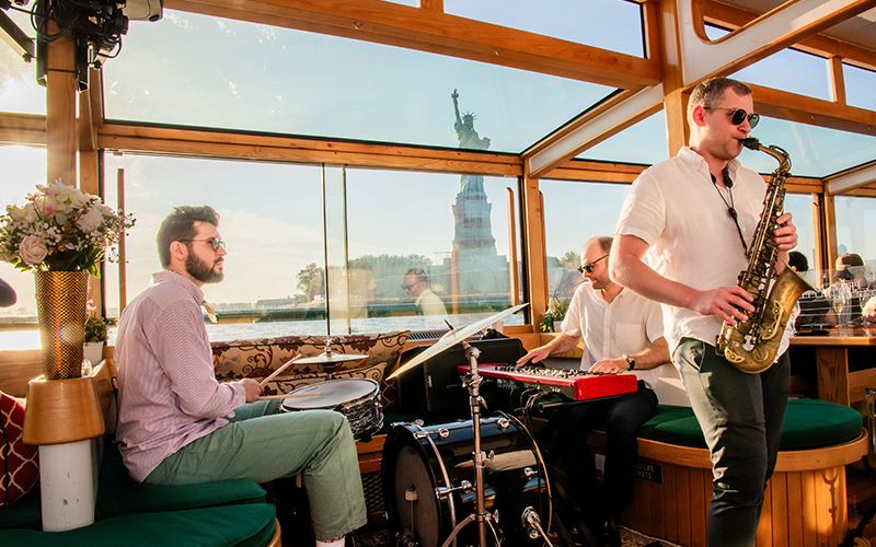 Musicians on a boat in front of the Statue of Liberty