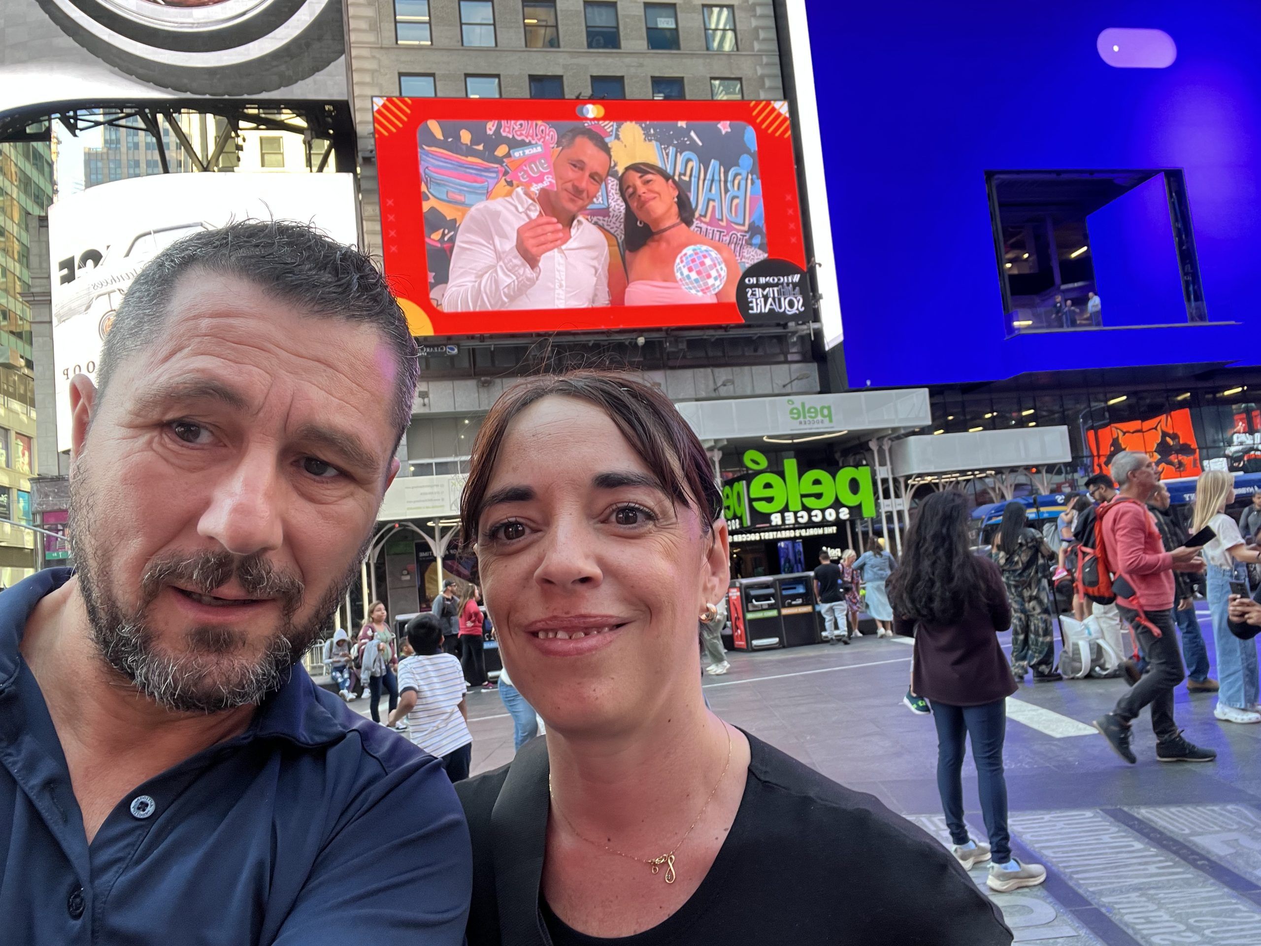 Couple in front of their photo on a Times Square screen in New York