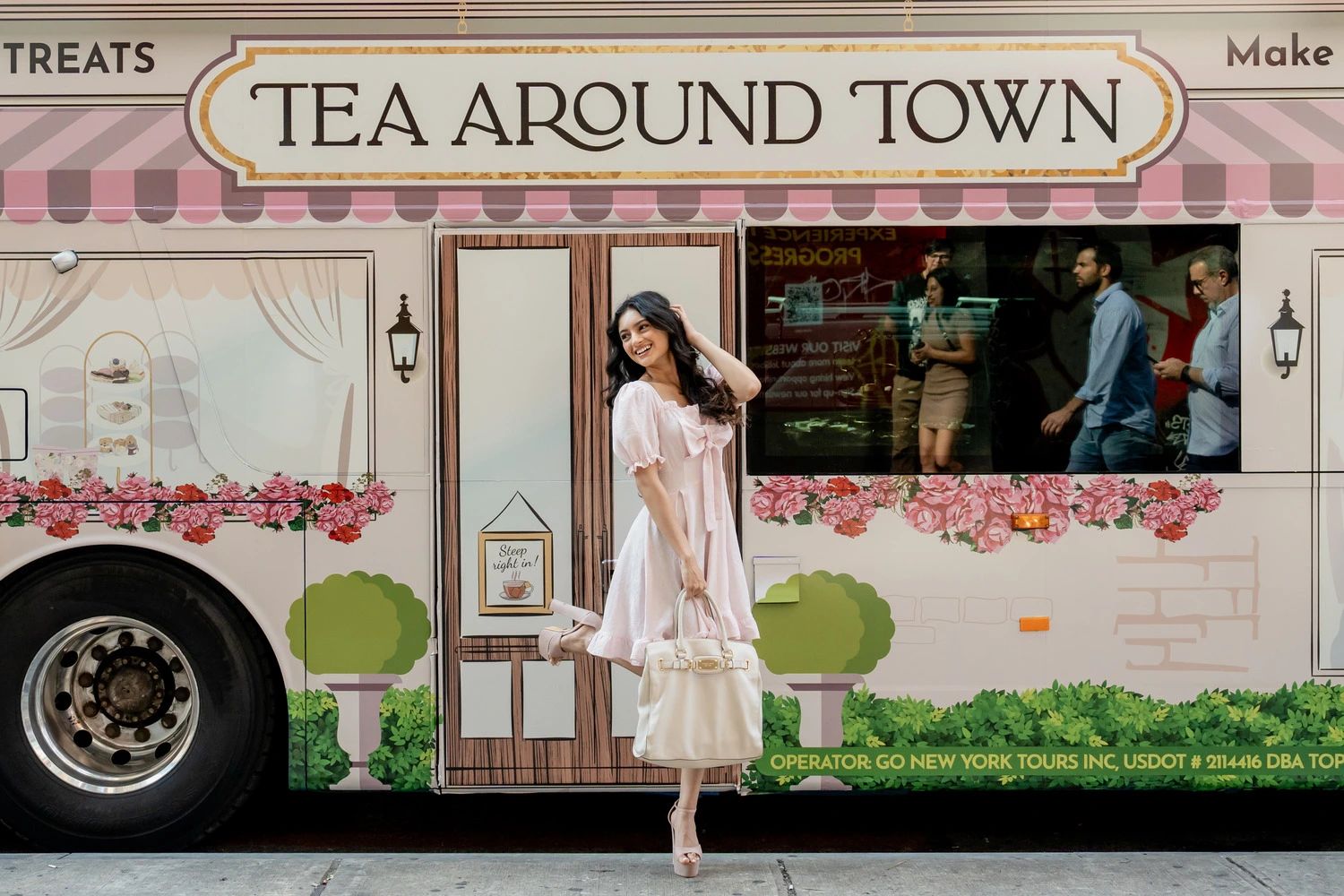 Young woman in front of a double-decker bus transformed into a tea salon in New York